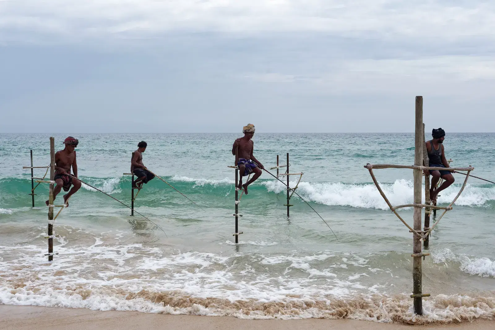 Stilt fishermen posing on their traditional poles near Galle